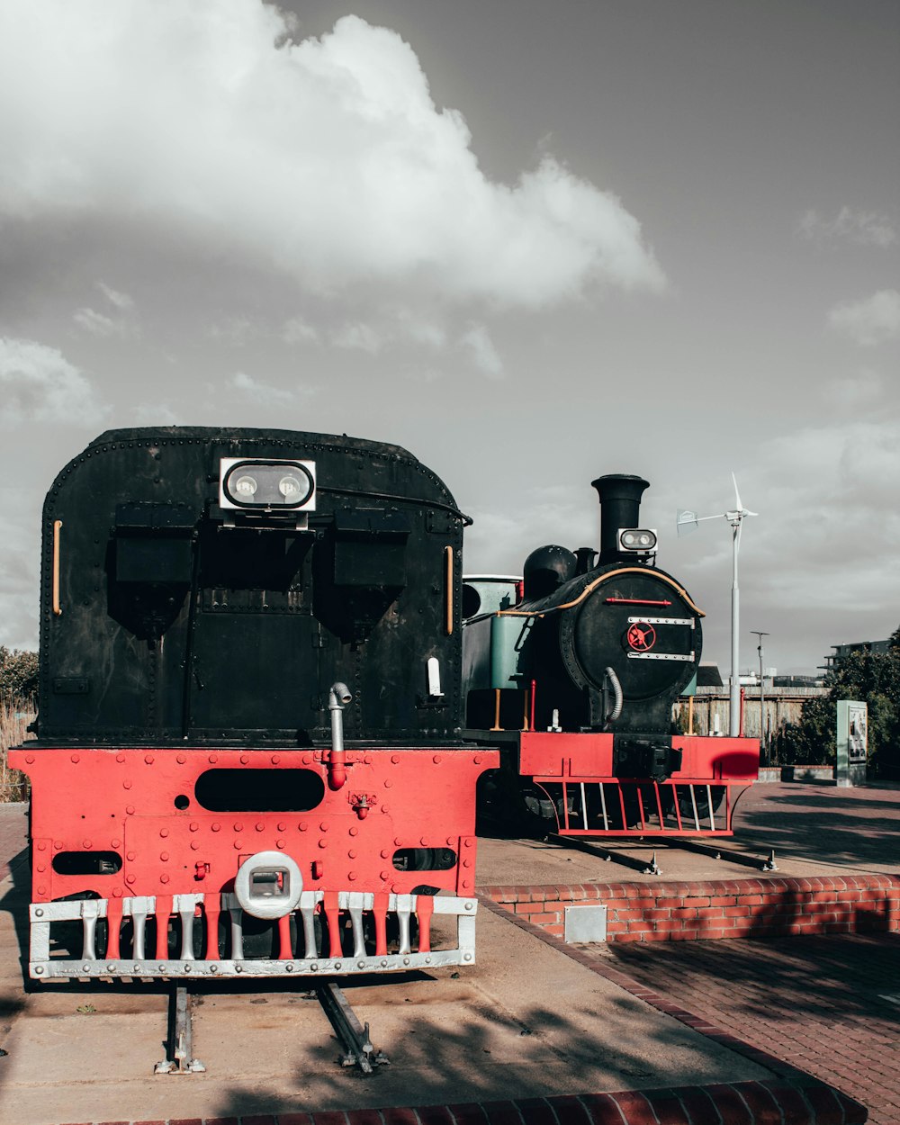 black and red train on rail tracks under cloudy sky during daytime