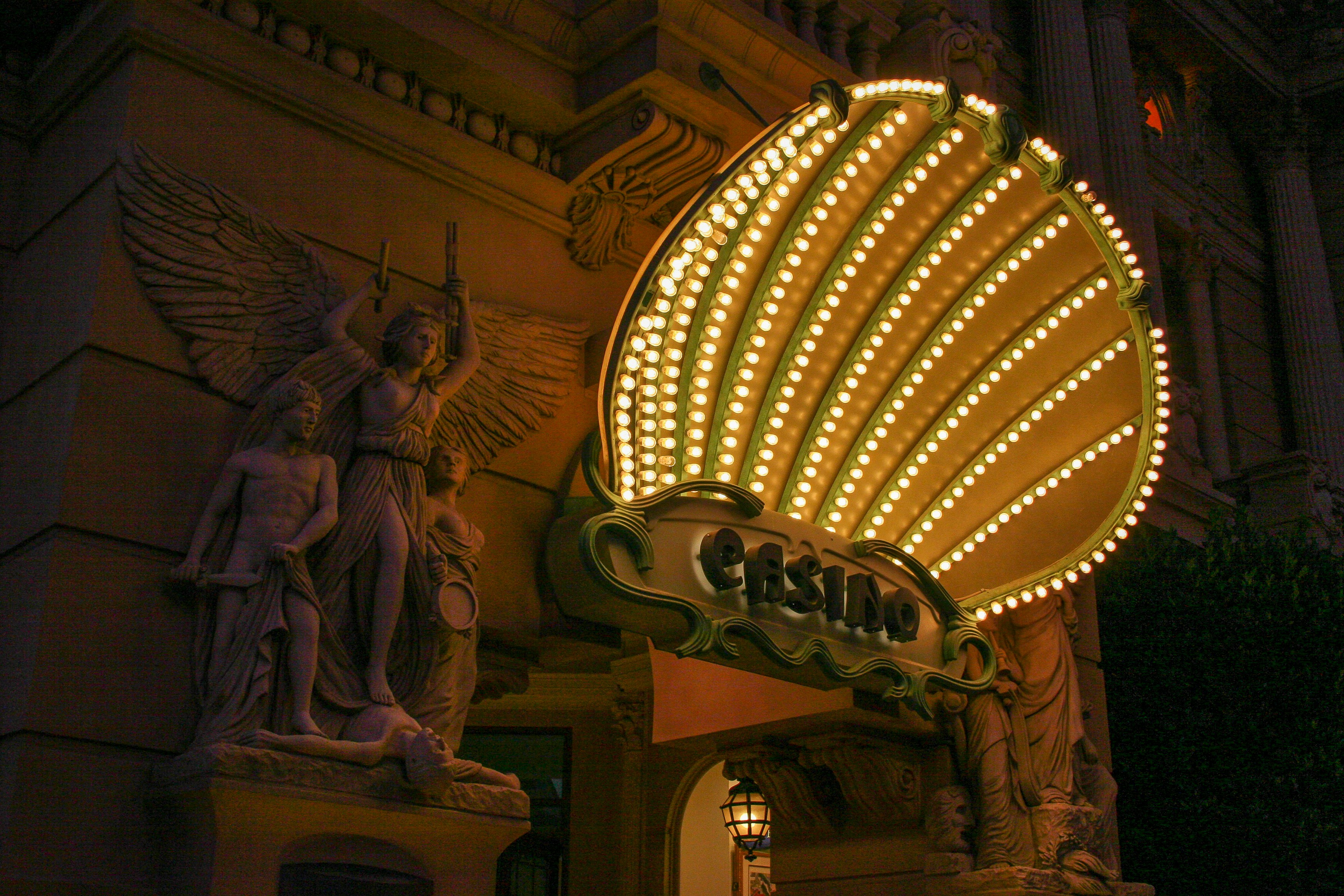 Neon casino entrance sign with statues