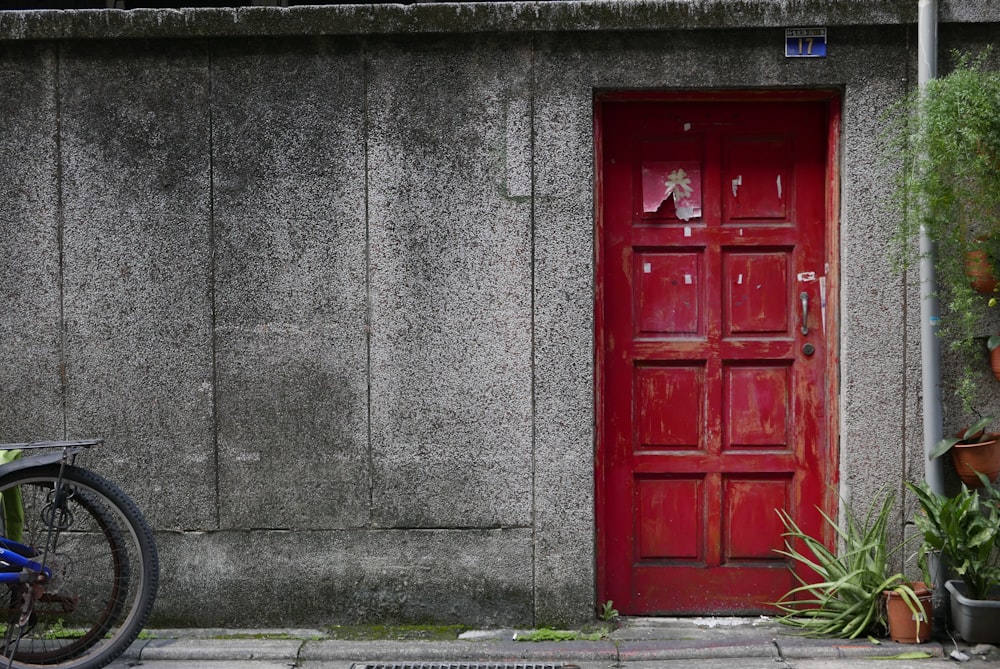 red wooden door on gray concrete wall