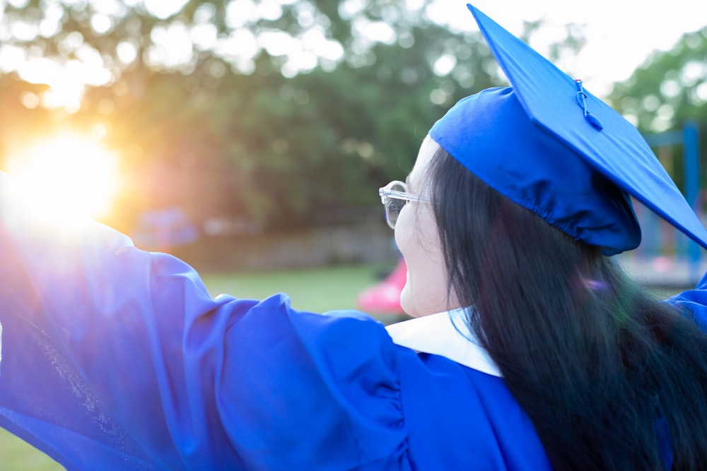 woman in blue academic dress wearing blue academic hat