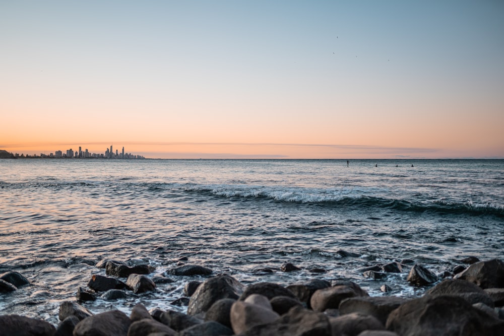 rocks on sea shore during sunset