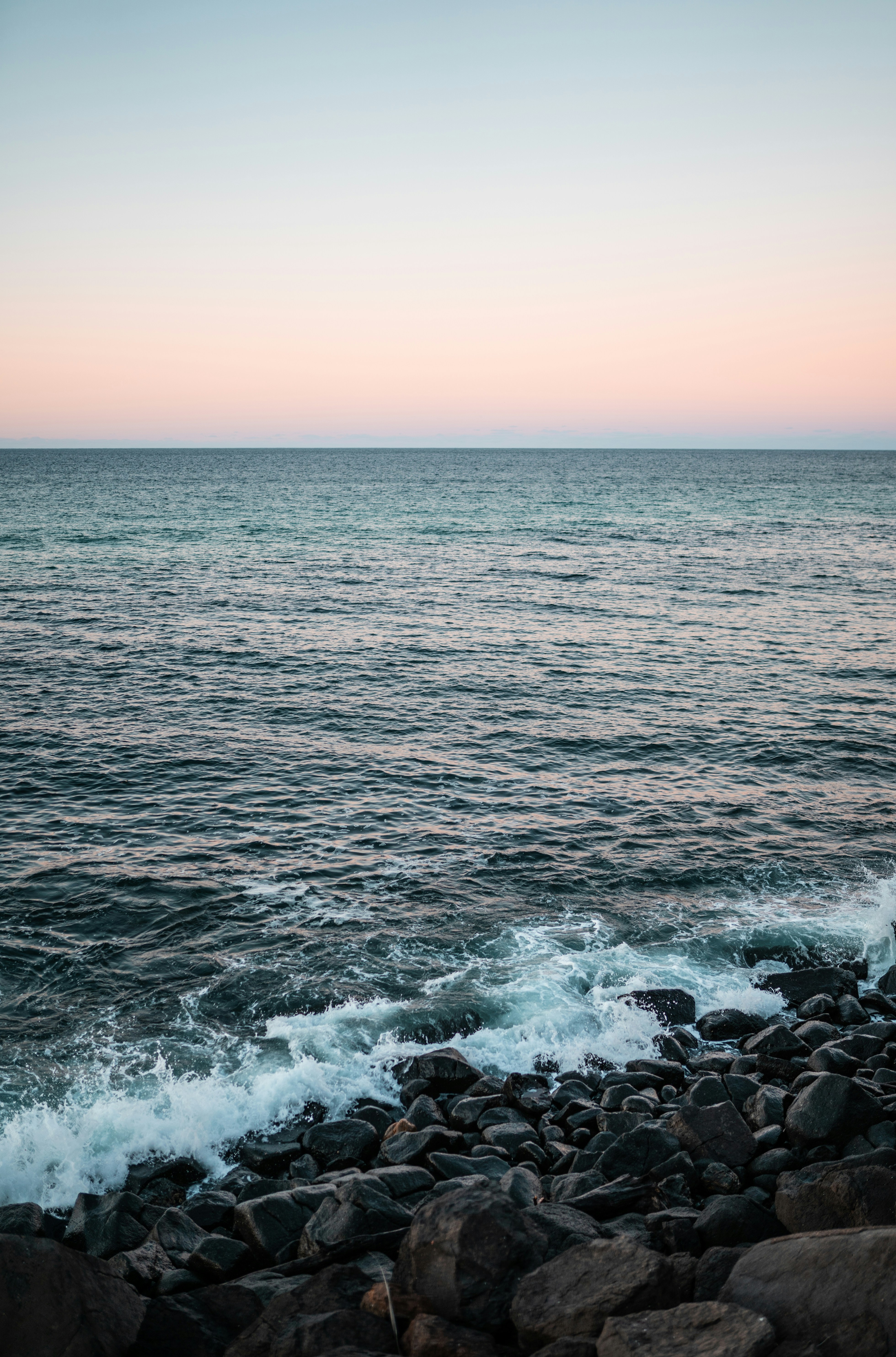 ocean waves crashing on rocks during sunset