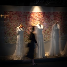 man and woman in wedding dress standing beside white floral curtain