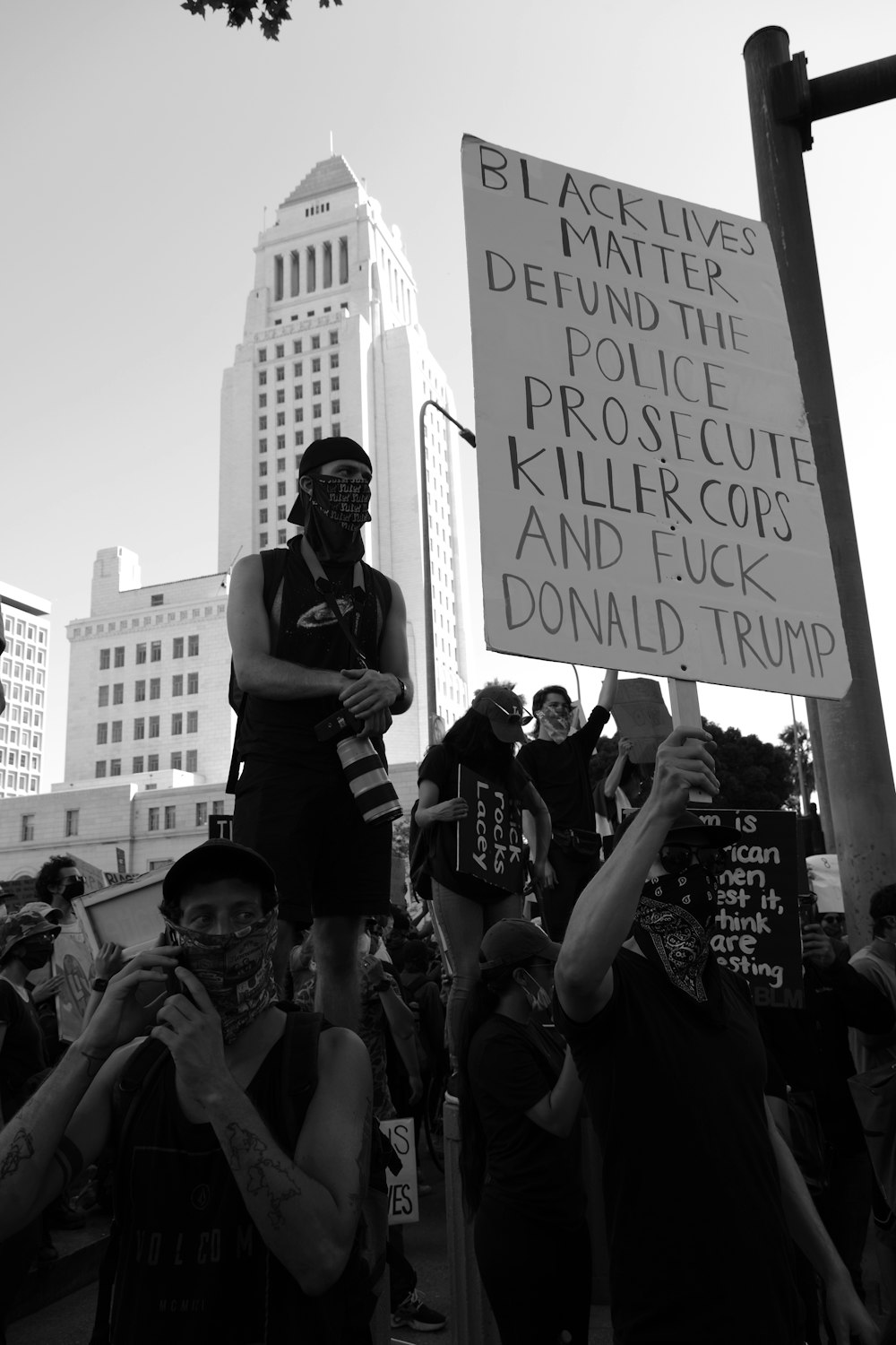 grayscale photo of man holding signage