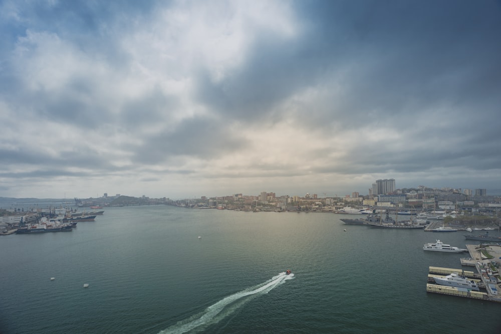 Barco blanco en el mar cerca de los edificios de la ciudad durante el día