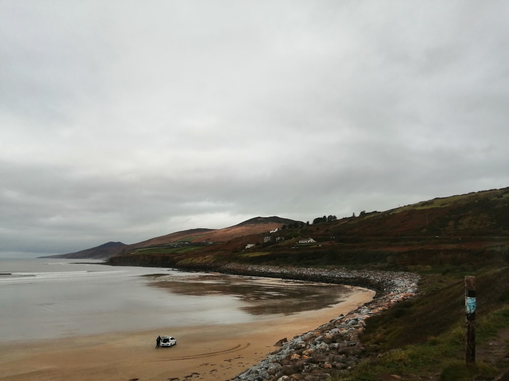 person walking on seashore during daytime