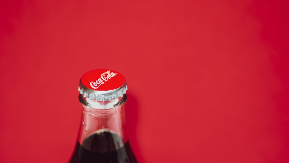 Bottiglia di Coca Cola su superficie rossa