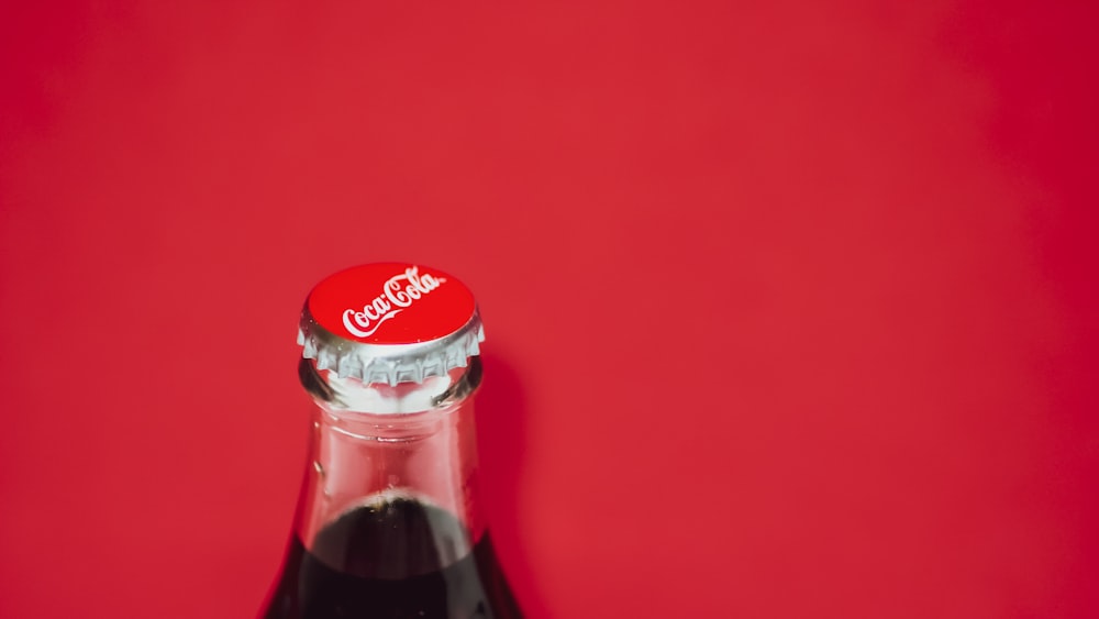 Botella de Coca Cola sobre superficie roja