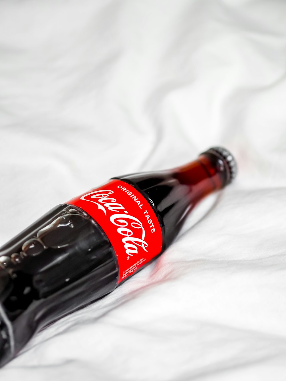 coca cola bottle on white textile