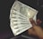 A hand holding multiple Indian 500 rupee banknotes, fanned out. The banknotes feature a portrait of Mahatma Gandhi and are from the Reserve Bank of India.