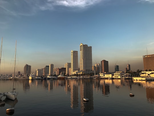 city skyline across body of water during daytime in Manila Bay Philippines