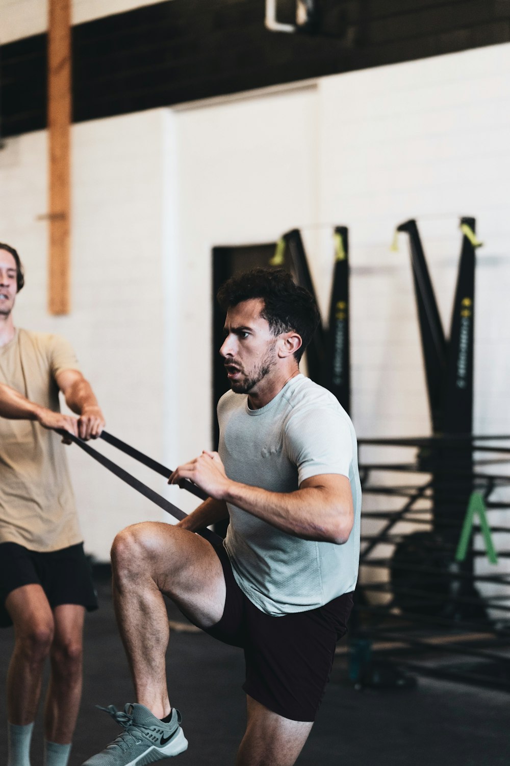 man in white crew neck t-shirt and black shorts sitting on brown wooden bench