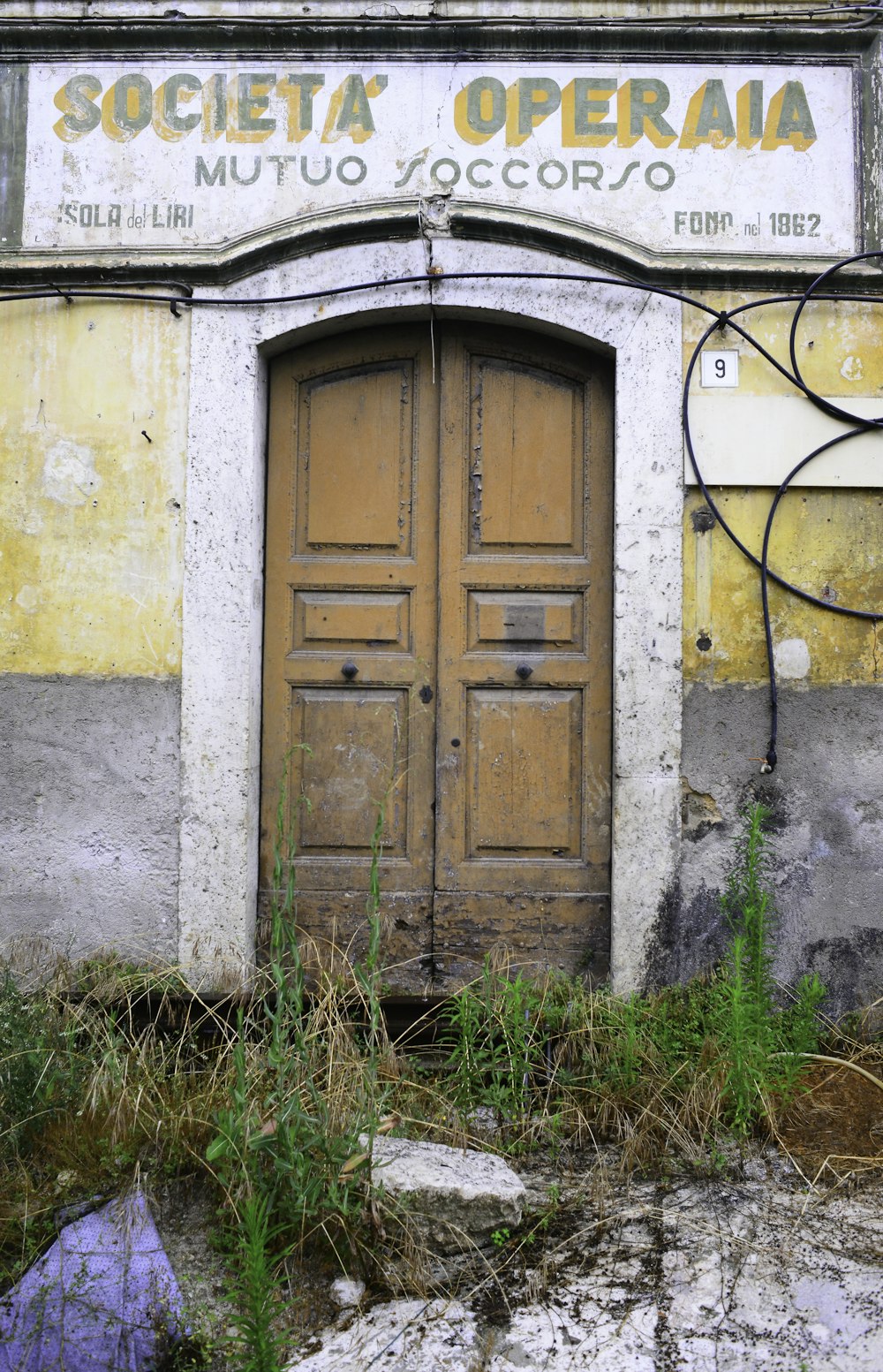 brown wooden door on white concrete wall