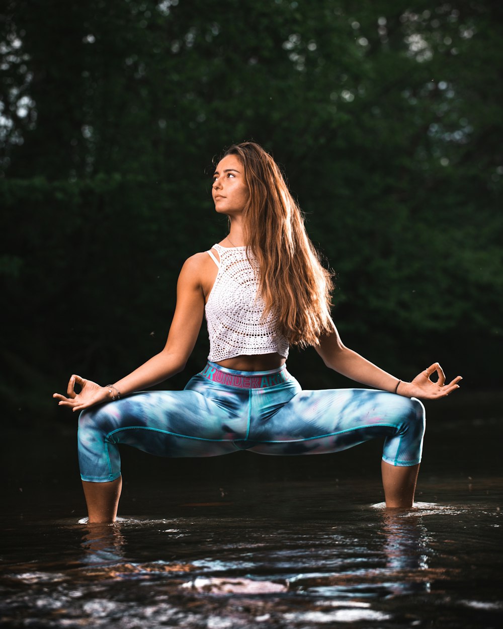 woman in gray tank top and blue denim jeans sitting on brown wooden dock during daytime