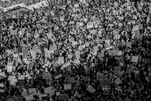 A black and white photo of protest signs held firmly in a crowded square.