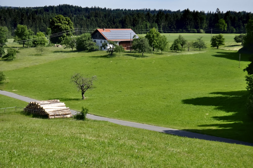 Maison en bois blanc et brun sur un champ d’herbe verte pendant la journée