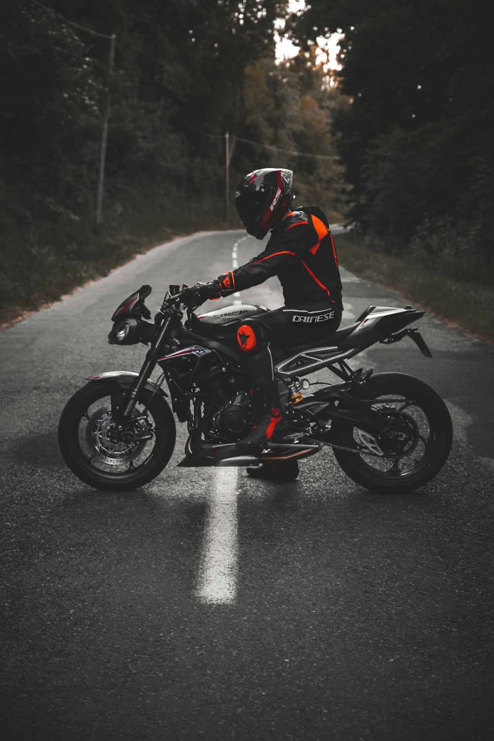 man in white and red jacket riding black sports bike on road during daytime