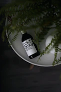 Sleek bottled cold-brew milk tea with condensation droplets, placed on a wooden table near a sunny window