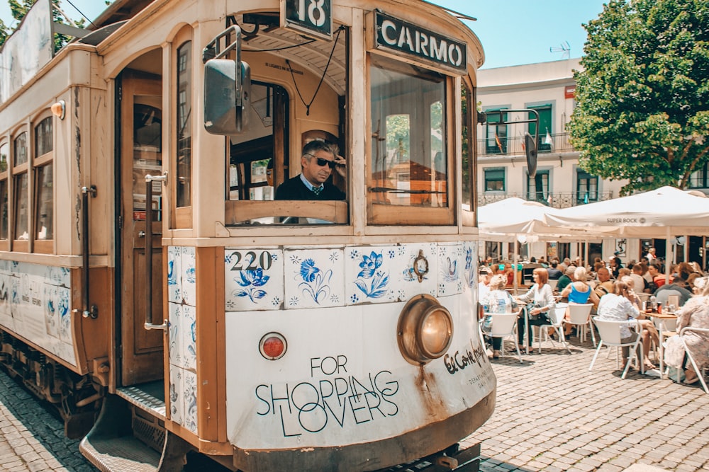 people riding on white and brown tram during daytime