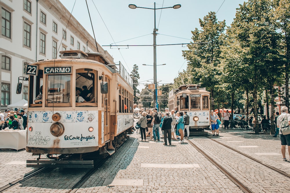 people walking on street near white and brown tram during daytime