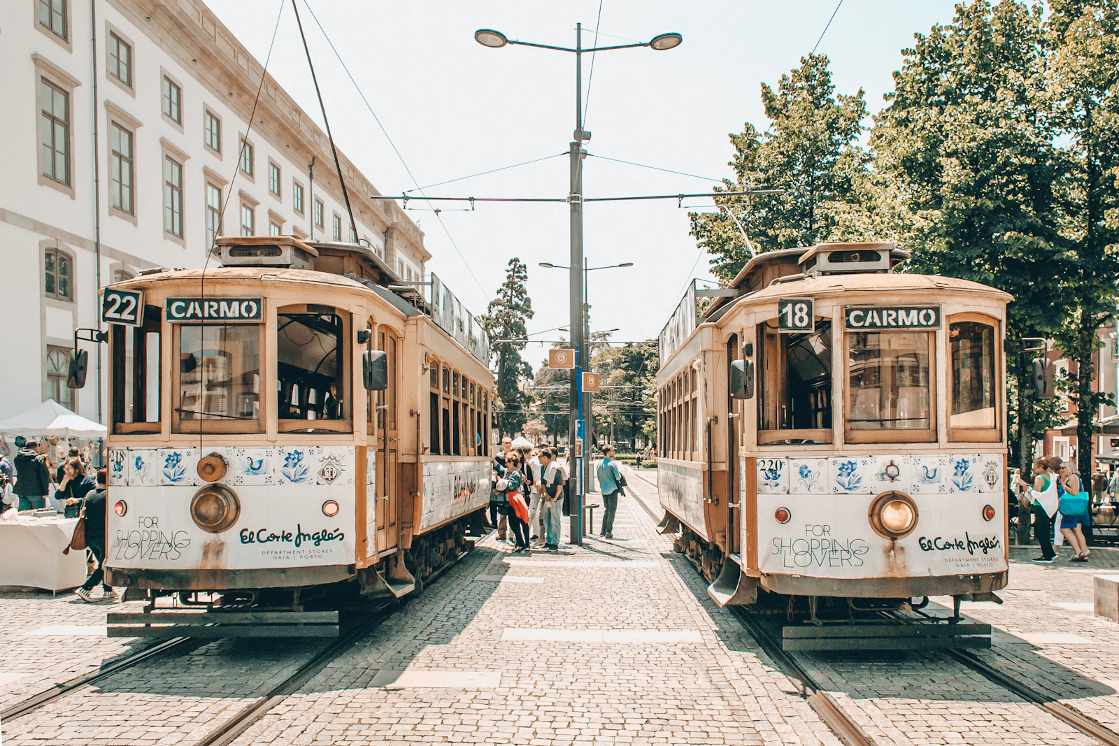 People walking on a Porto street beside a historic tram during daytime
