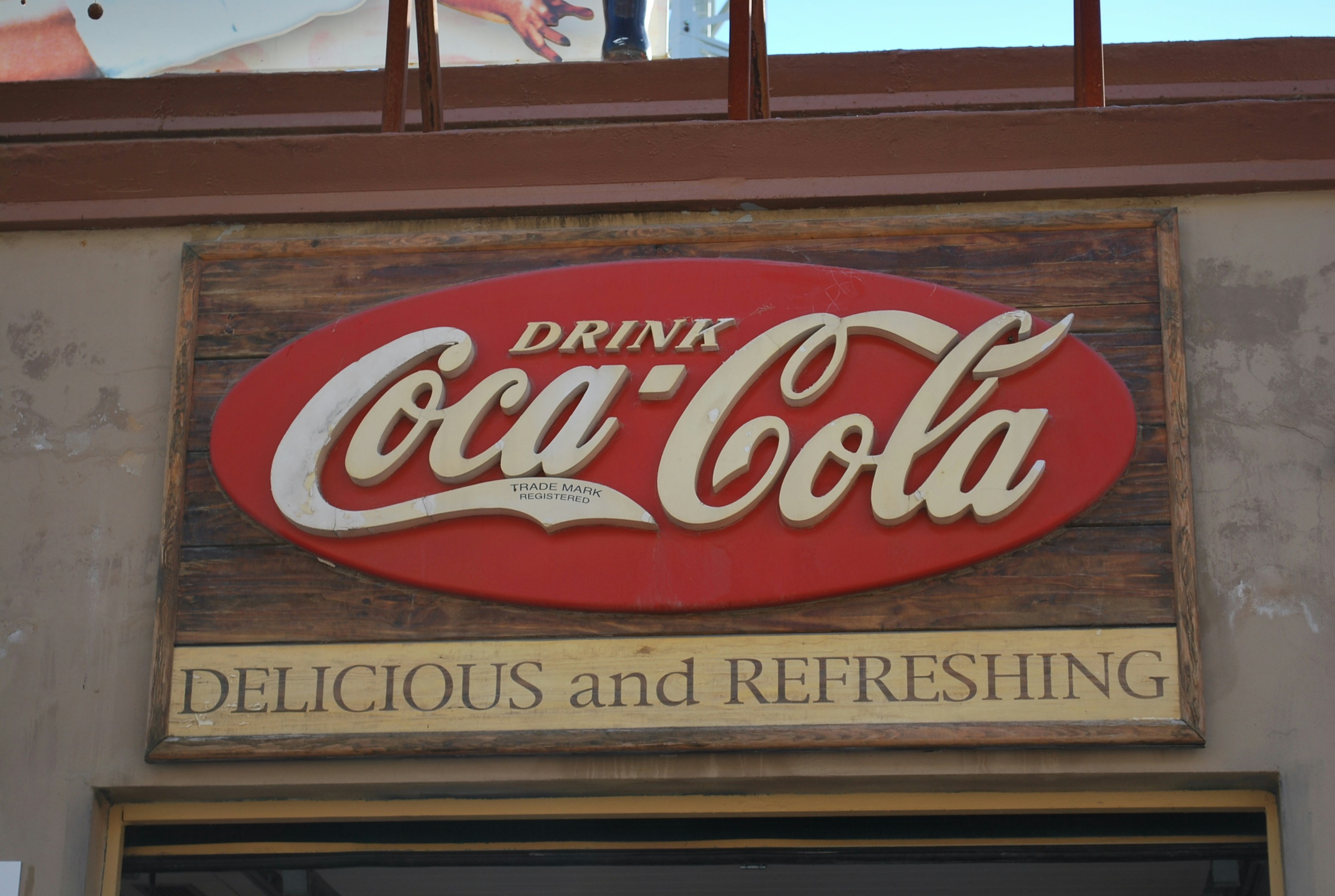 Vintage red embossed tin Coca-Cola advertising sign with original paint