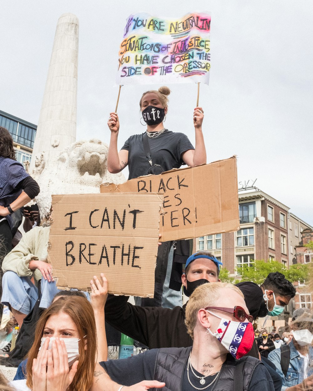 people holding brown wooden signage during daytime