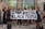 A group of people, predominantly wearing face masks, are gathered in a public space holding signs advocating against racism. The central focus is a large banner with the message 'Stop Killing Black People'. Another sign reads 'Sta op tegen racisme wereldwijd', which translates to 'Stand up against racism worldwide'. The individuals display diverse styles of clothing and appear unified in purpose.