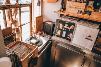 A cozy studio corner with vintage vinyl records and a glowing mixing console.