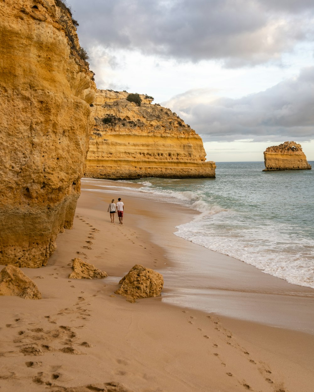 persone che camminano sulla spiaggia durante il giorno