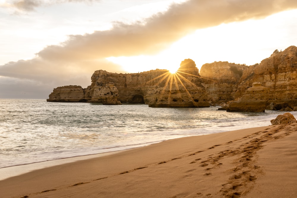 brown rock formation on sea shore during sunset