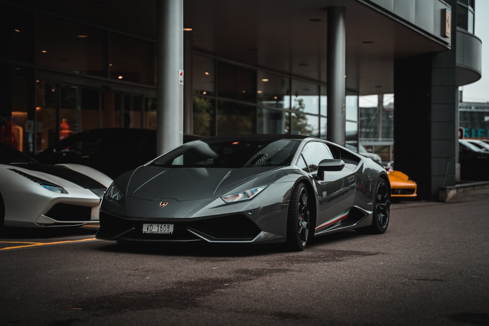 black lamborghini aventador parked in front of white building