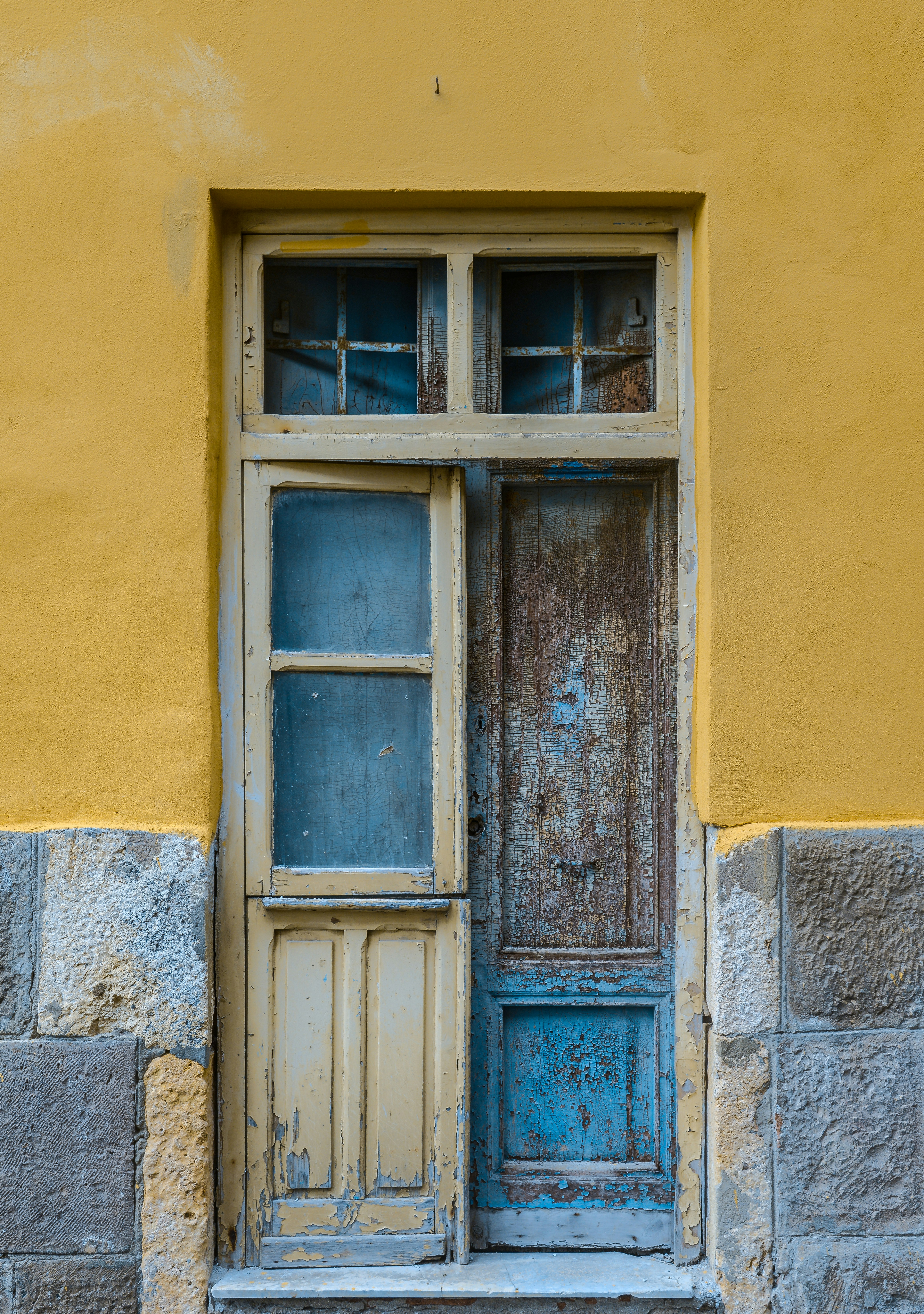 blue wooden window on yellow concrete wall