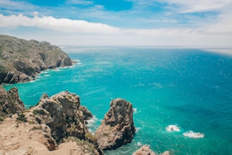 brown rock formation on blue sea under blue sky during daytime