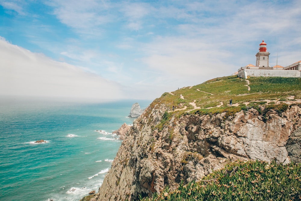 a lighthouse on a cliff overlooking the ocean