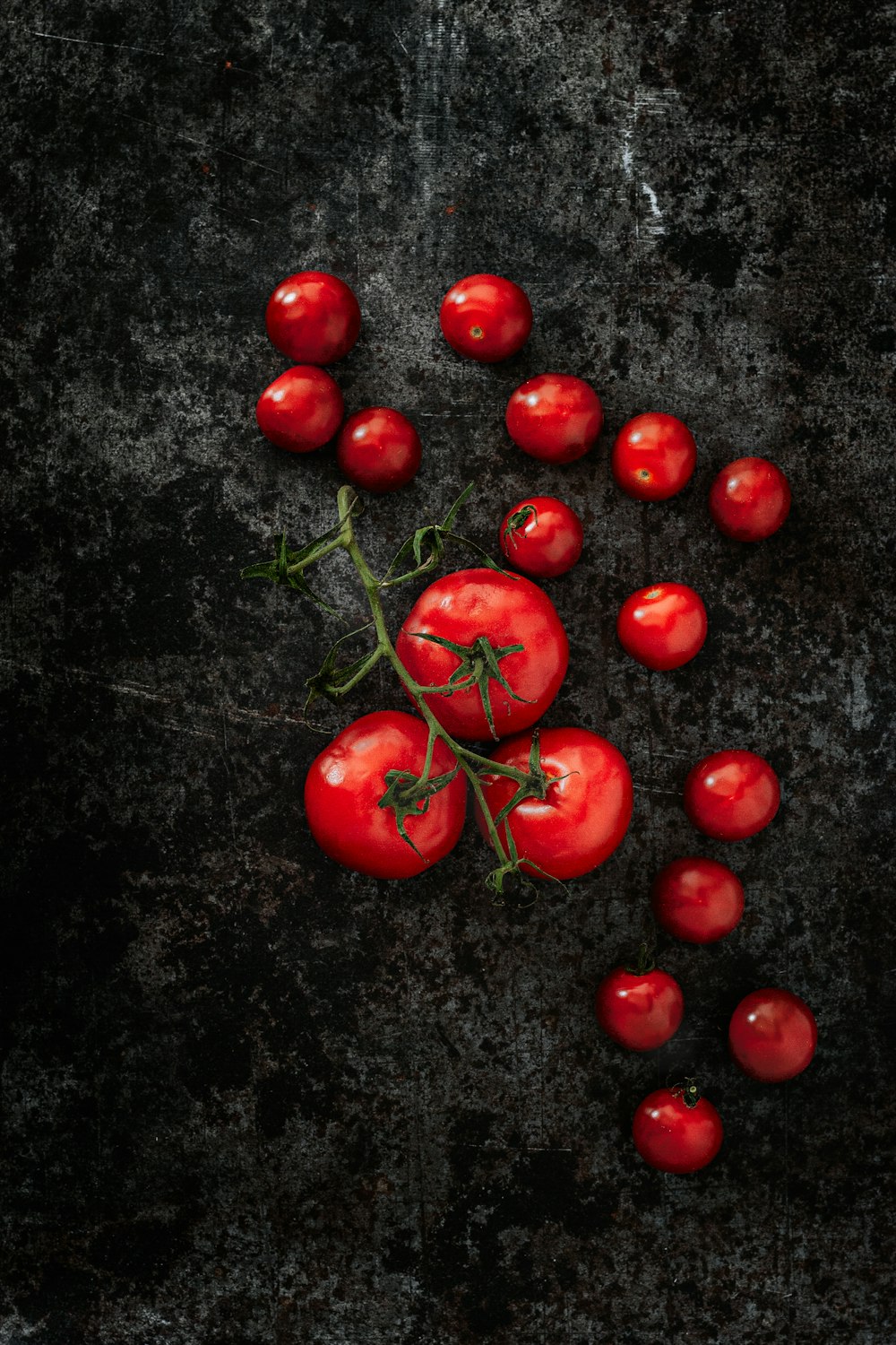 pomodorini rossi su superficie nera