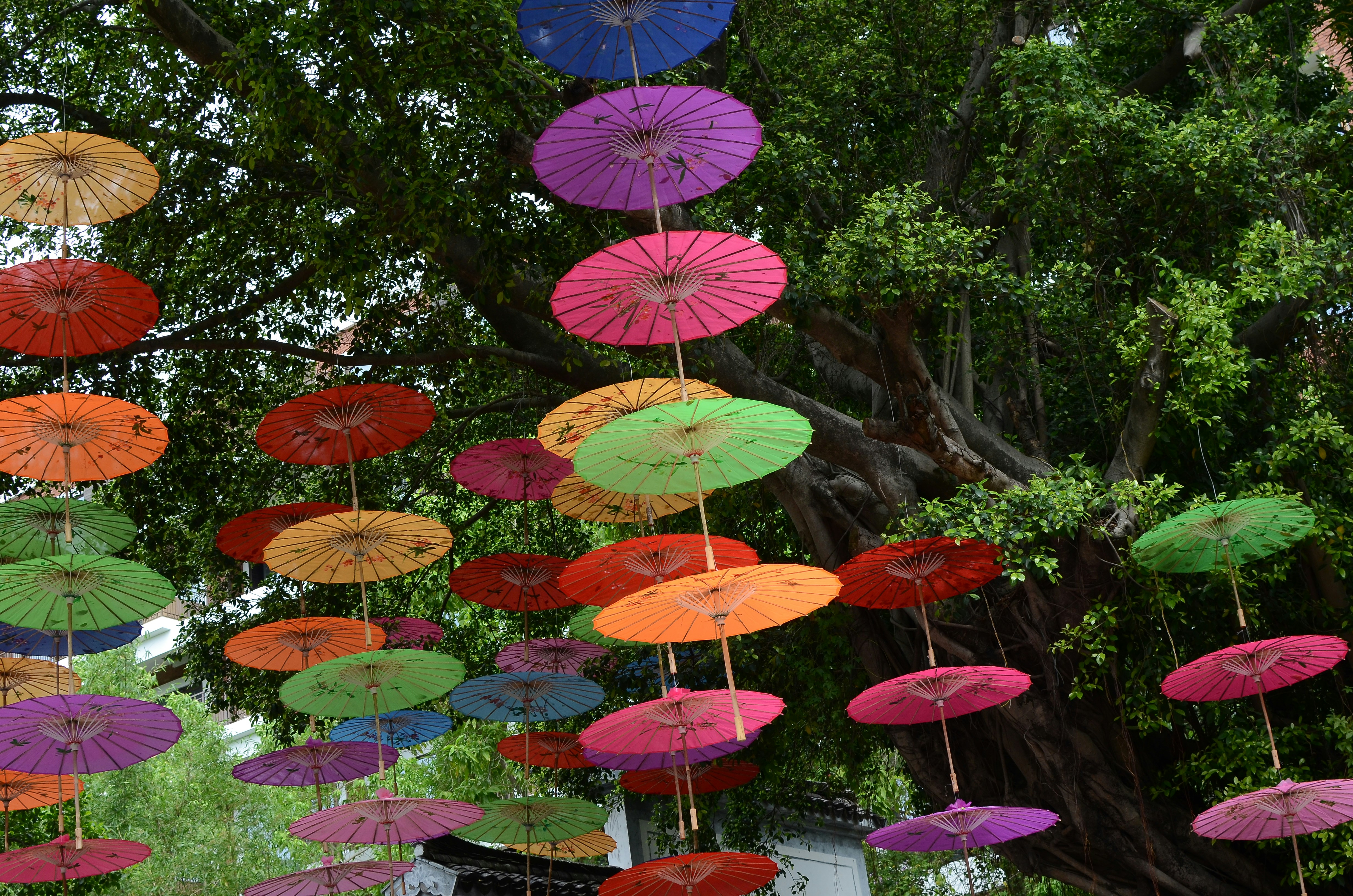 Paraguas rojo y amarillo sobre piso de concreto gris