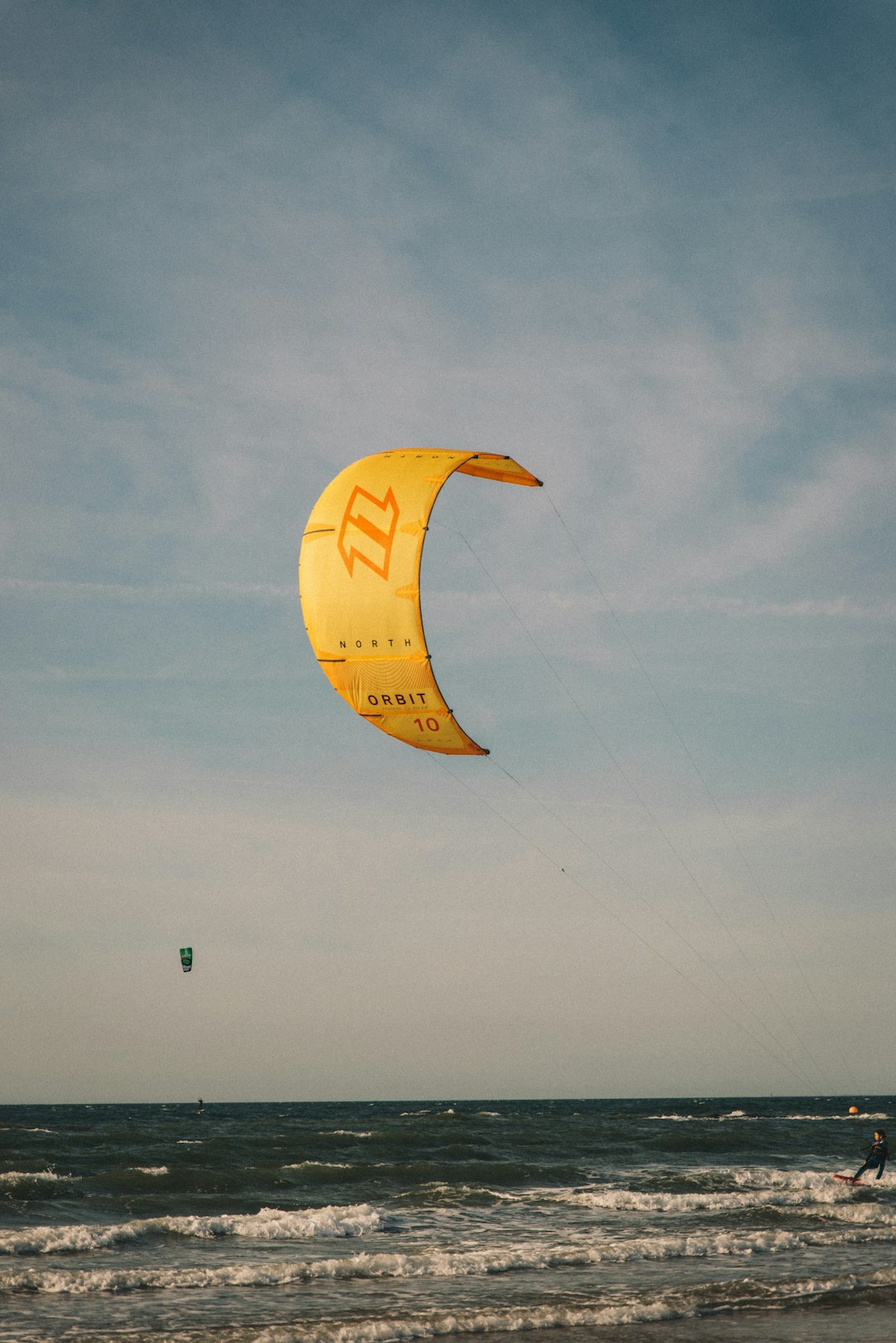 yellow parachute under white clouds during daytime