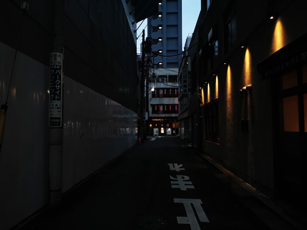 black asphalt road between buildings during night time