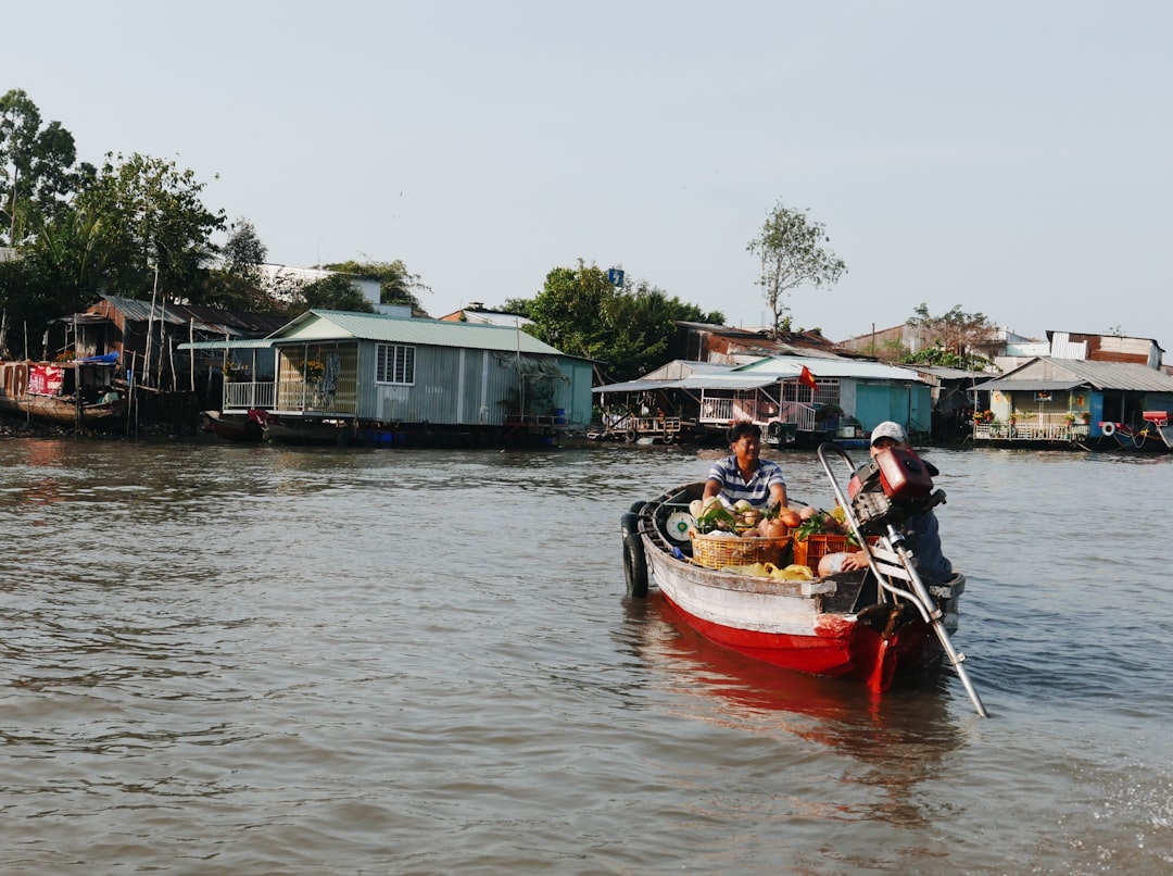 people riding on red boat on river during daytime