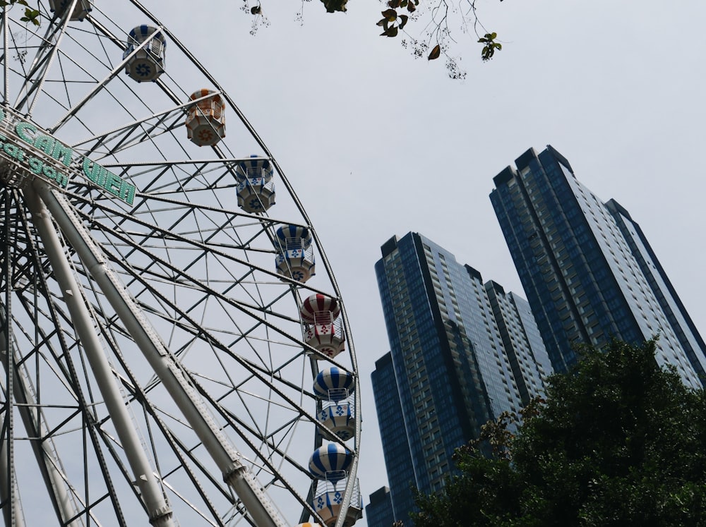 white ferris wheel near high rise buildings during daytime