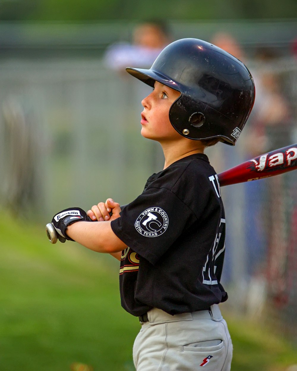 menino na camisa de beisebol preta e branca e capacete