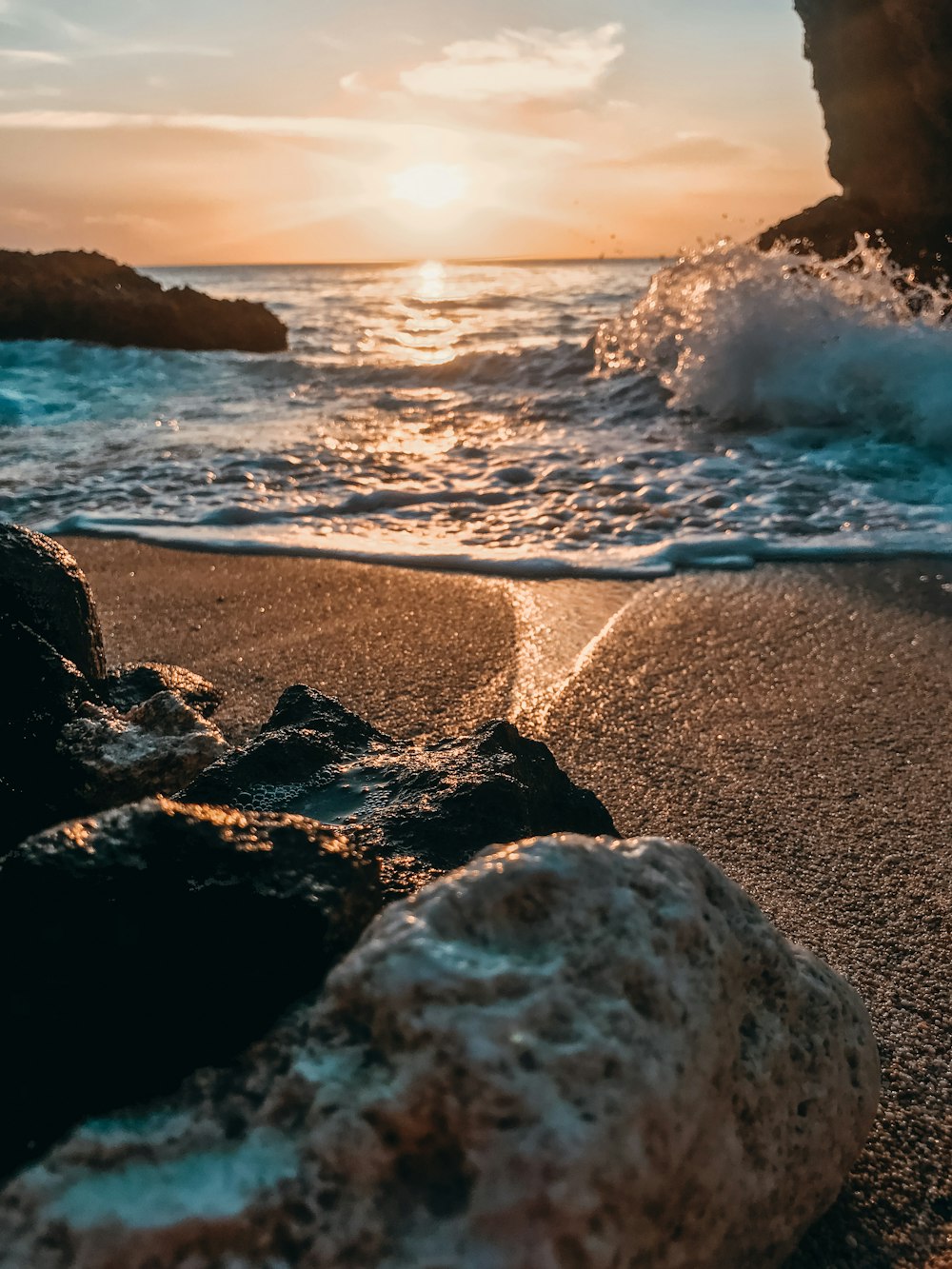 ocean waves crashing on shore during sunset