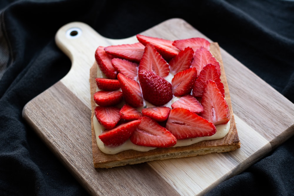 sliced strawberries on brown wooden chopping board