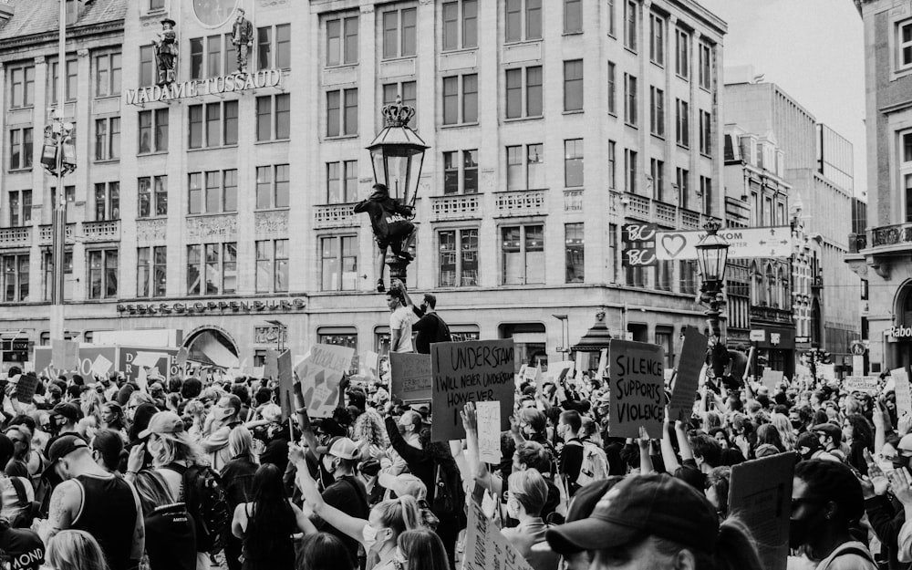 grayscale photo of people in front of building