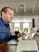 Man reviewing loan options on a laptop with a cup of coffee nearby, showing focus and satisfaction.