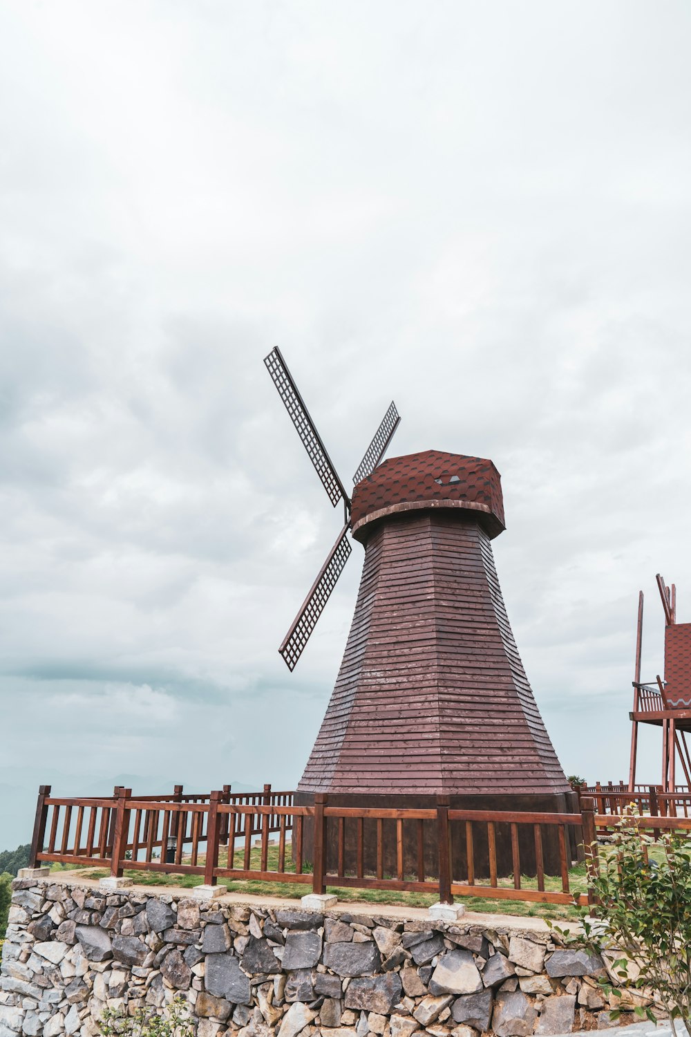 red and brown windmill under cloudy sky during daytime