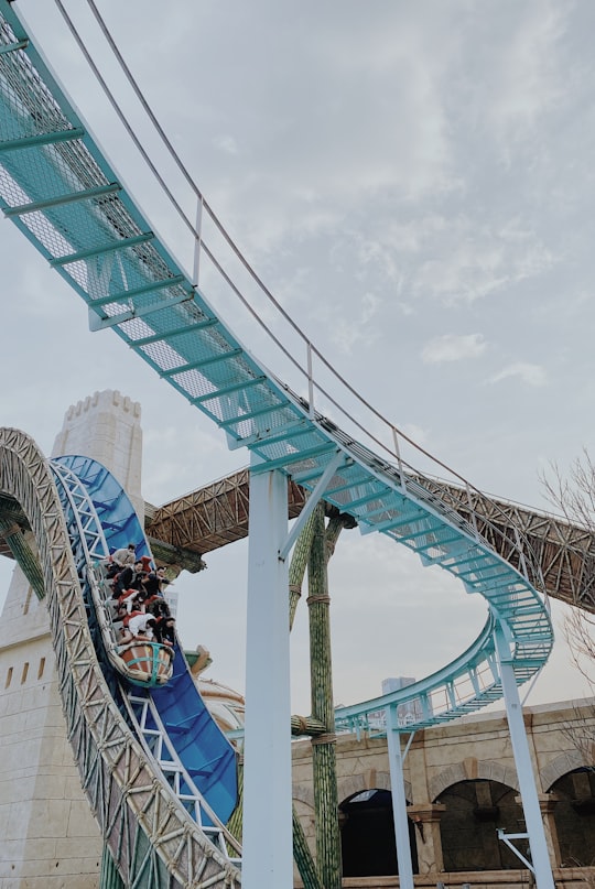 people walking on teal and white bridge during daytime in Lotte World South Korea