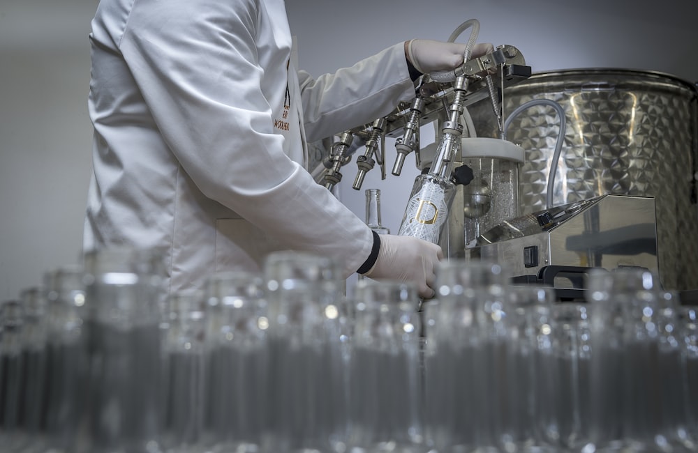 person in white chef uniform holding clear glass bottle