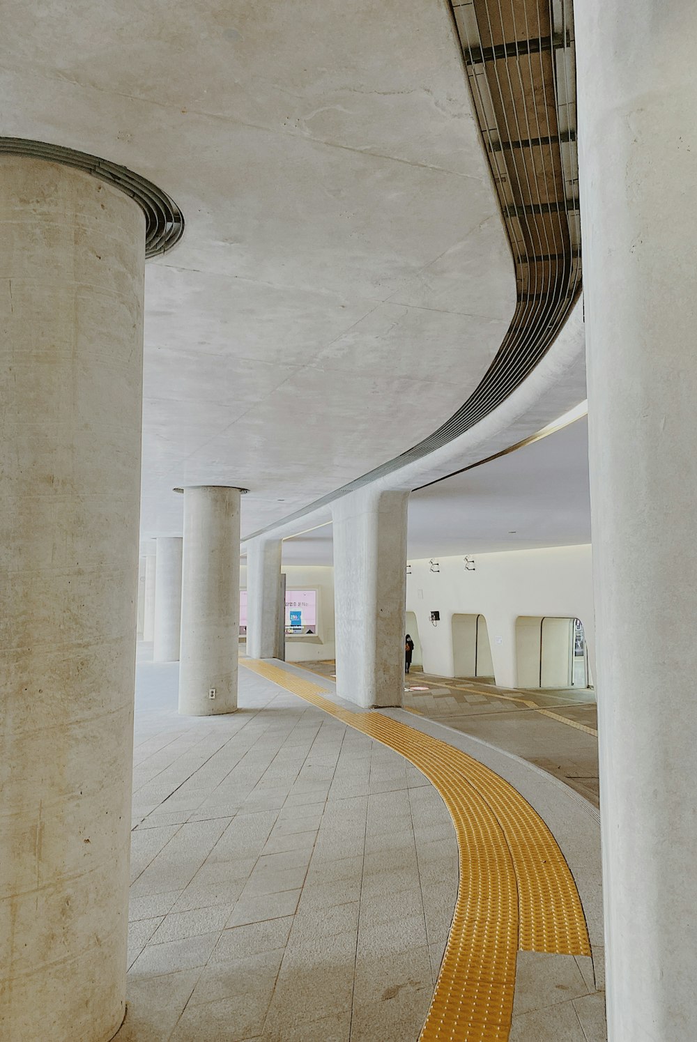 an empty walkway in a large building with columns